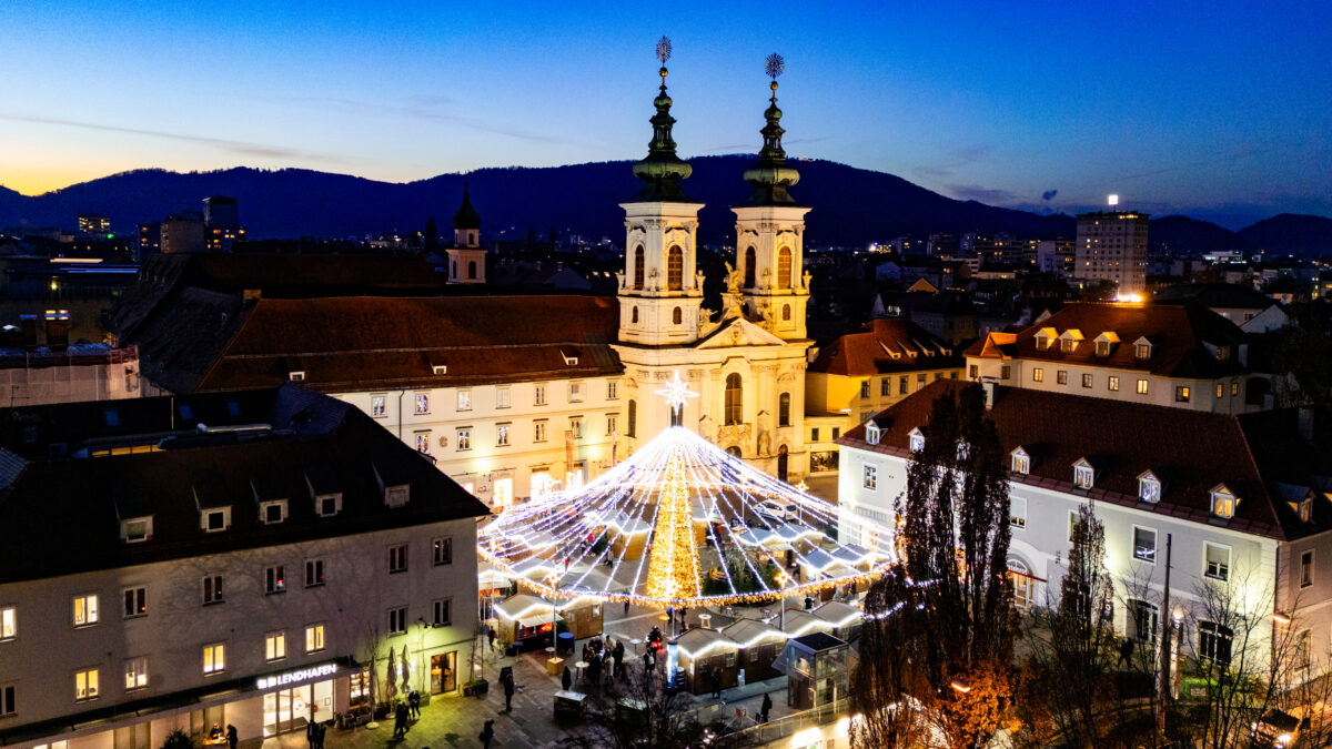 Blick auf den Grazer Hauptplatz mit Lichterketten und der Franziskanerkirche.