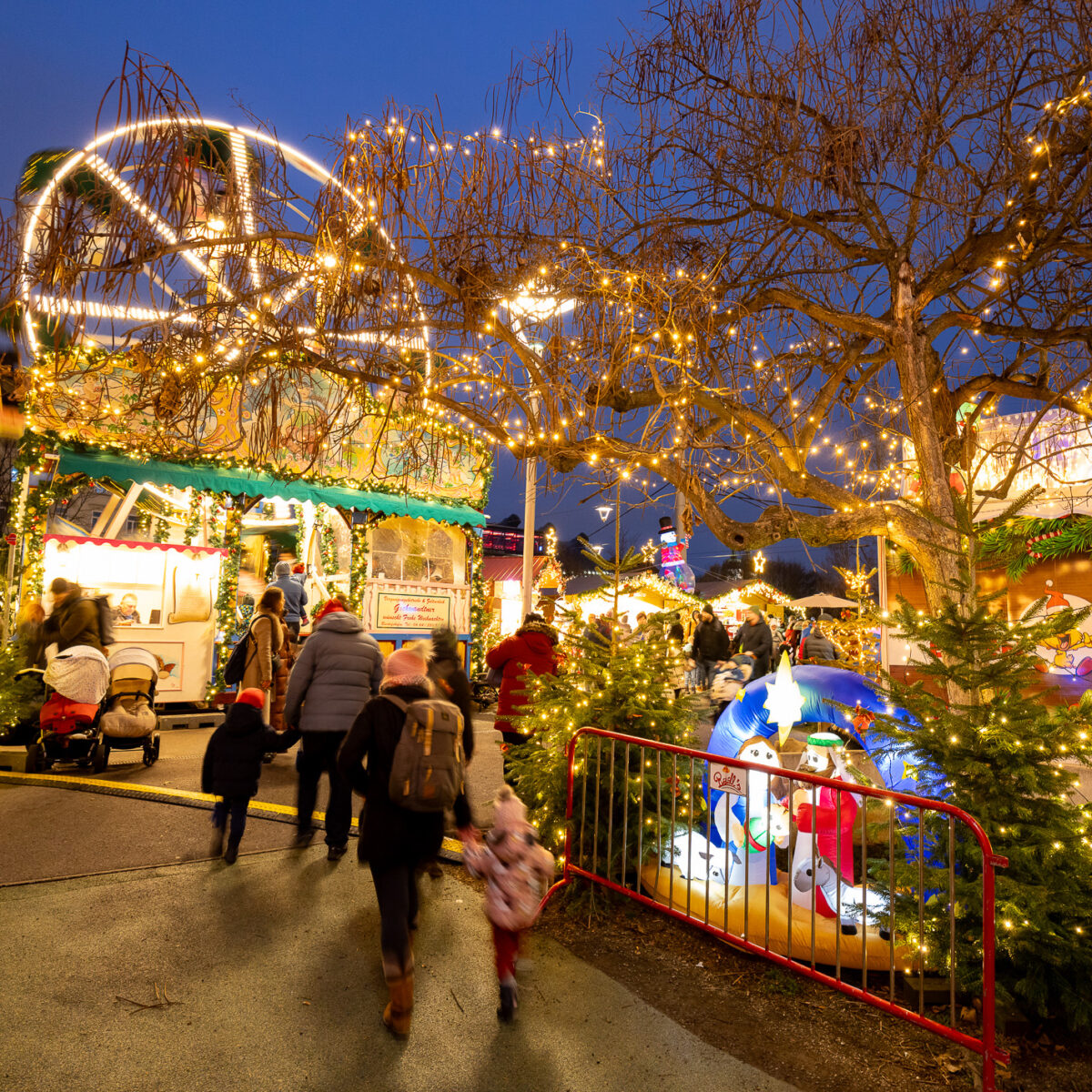 Weihnachtsmarkt Graz mit beleuchtetem Riesenrad und Menschen.