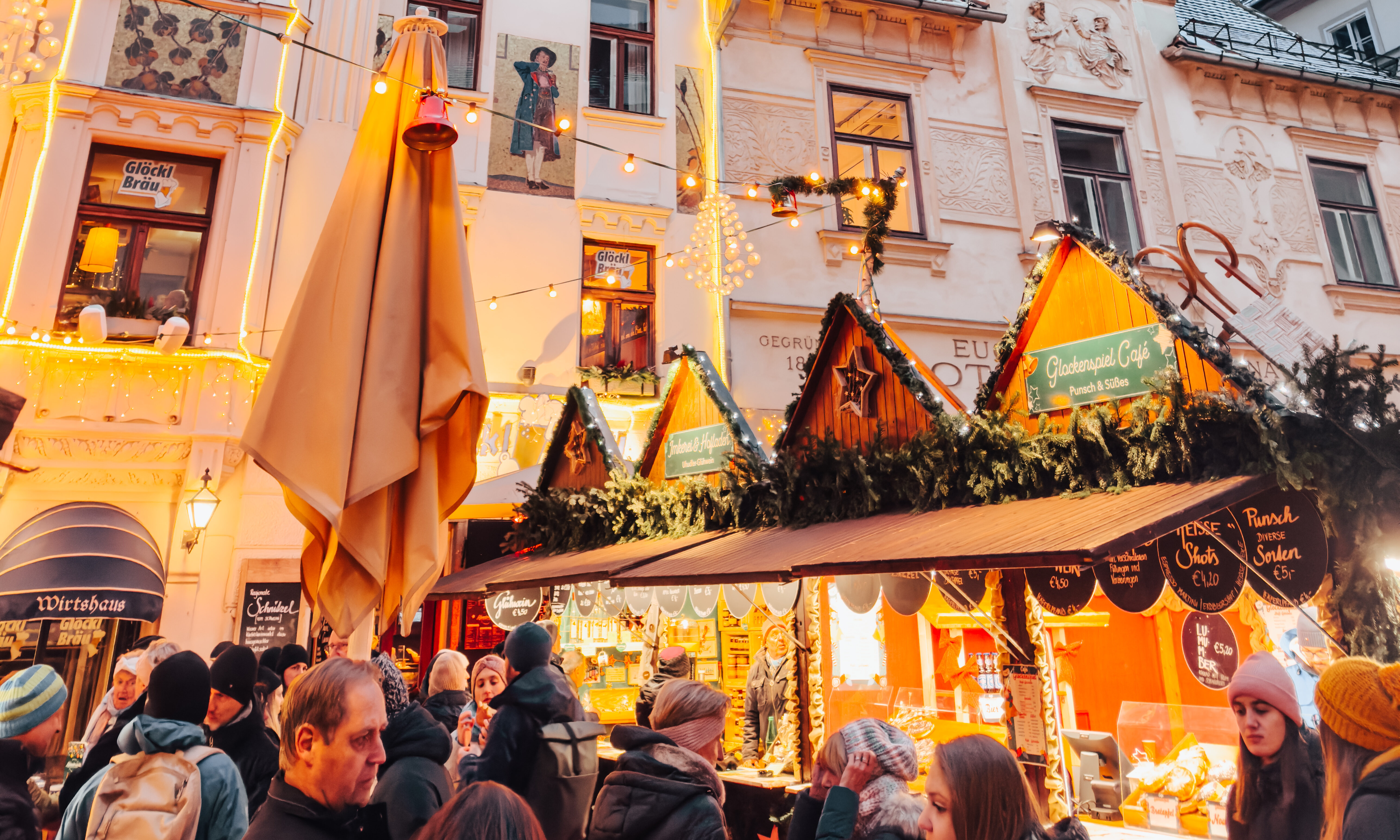 Weihnachtsmarkt in Graz mit beleuchteten Hütten und Menschenmenge.