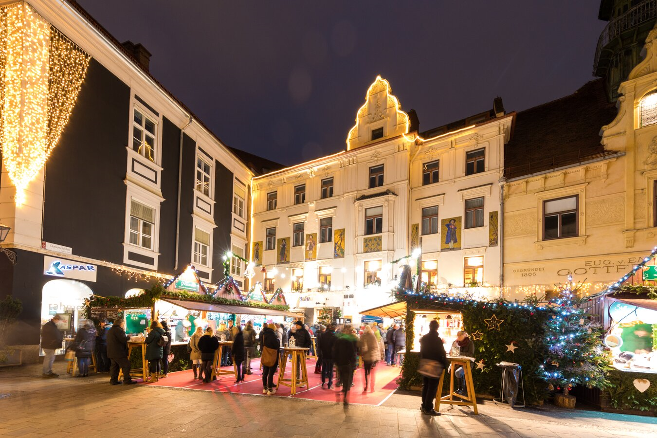 Festlich beleuchteter Adventmarkt in Graz, im Hintergrund historische Gebäude.