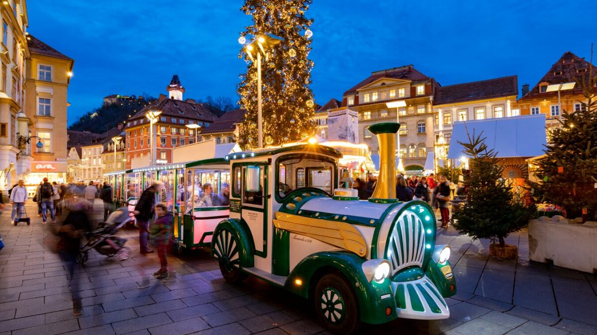 Graz Christmas market with illuminated train and tree.