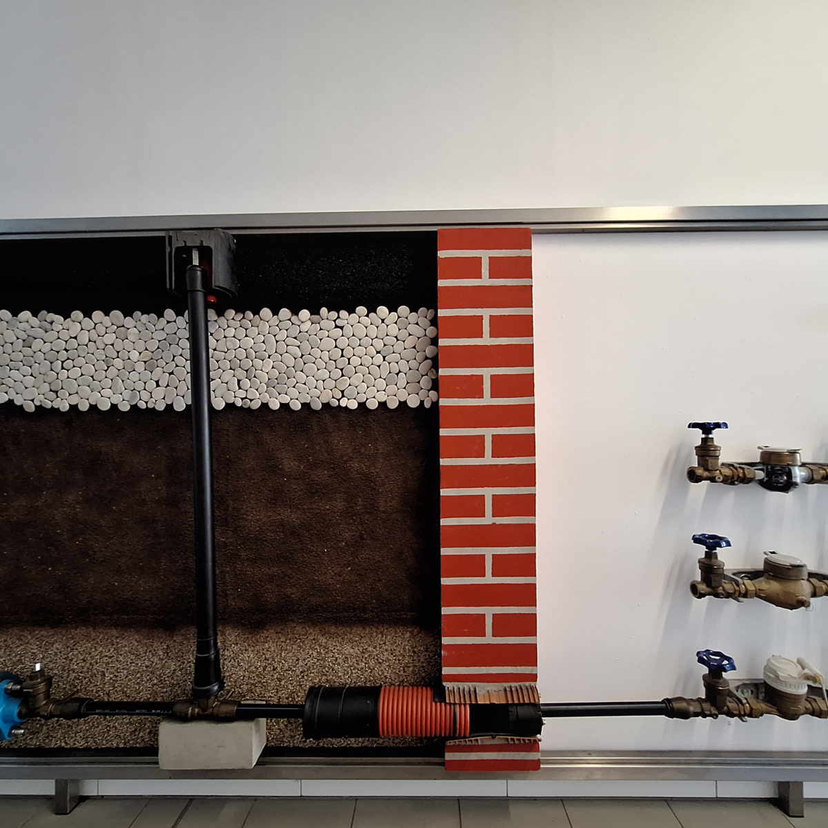 Wall exhibit of water main connection components.