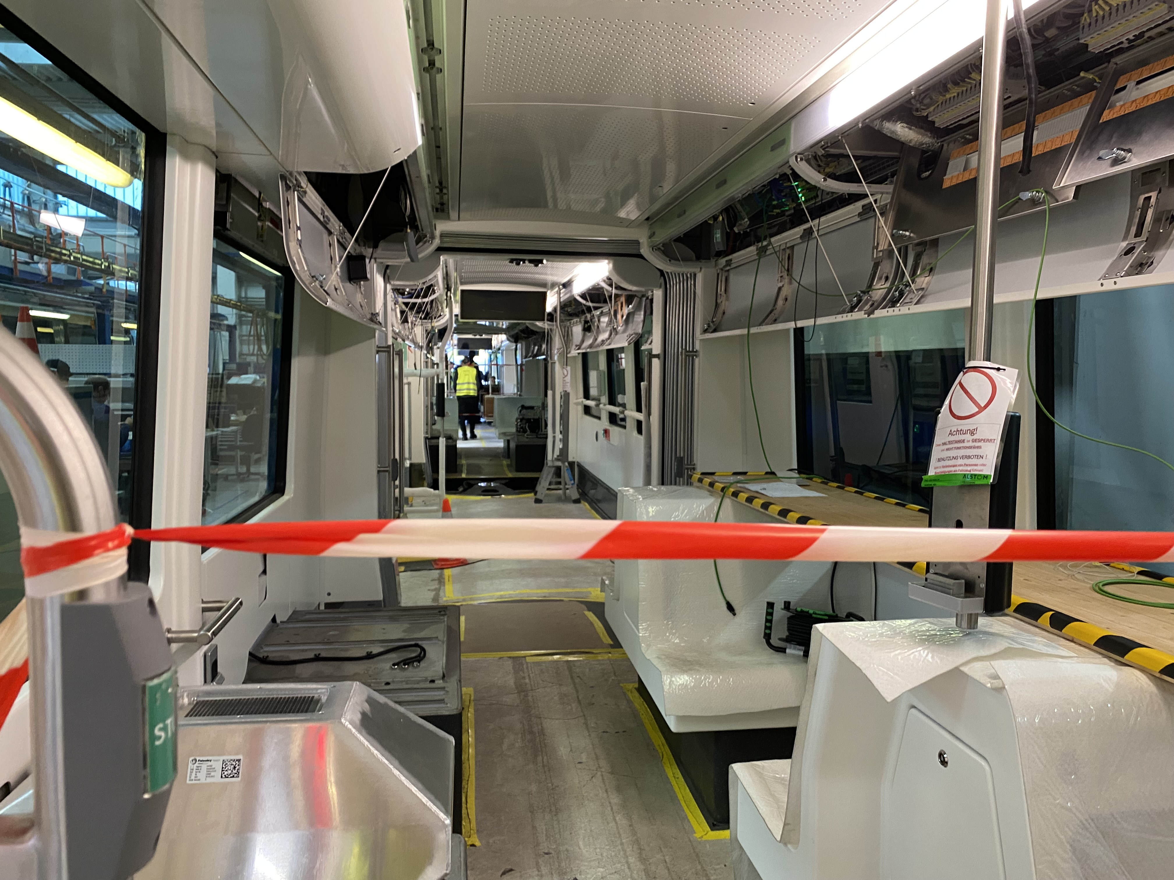 Innenraum einer Straßenbahn im Bau, mit Absperrband und Warnschild.