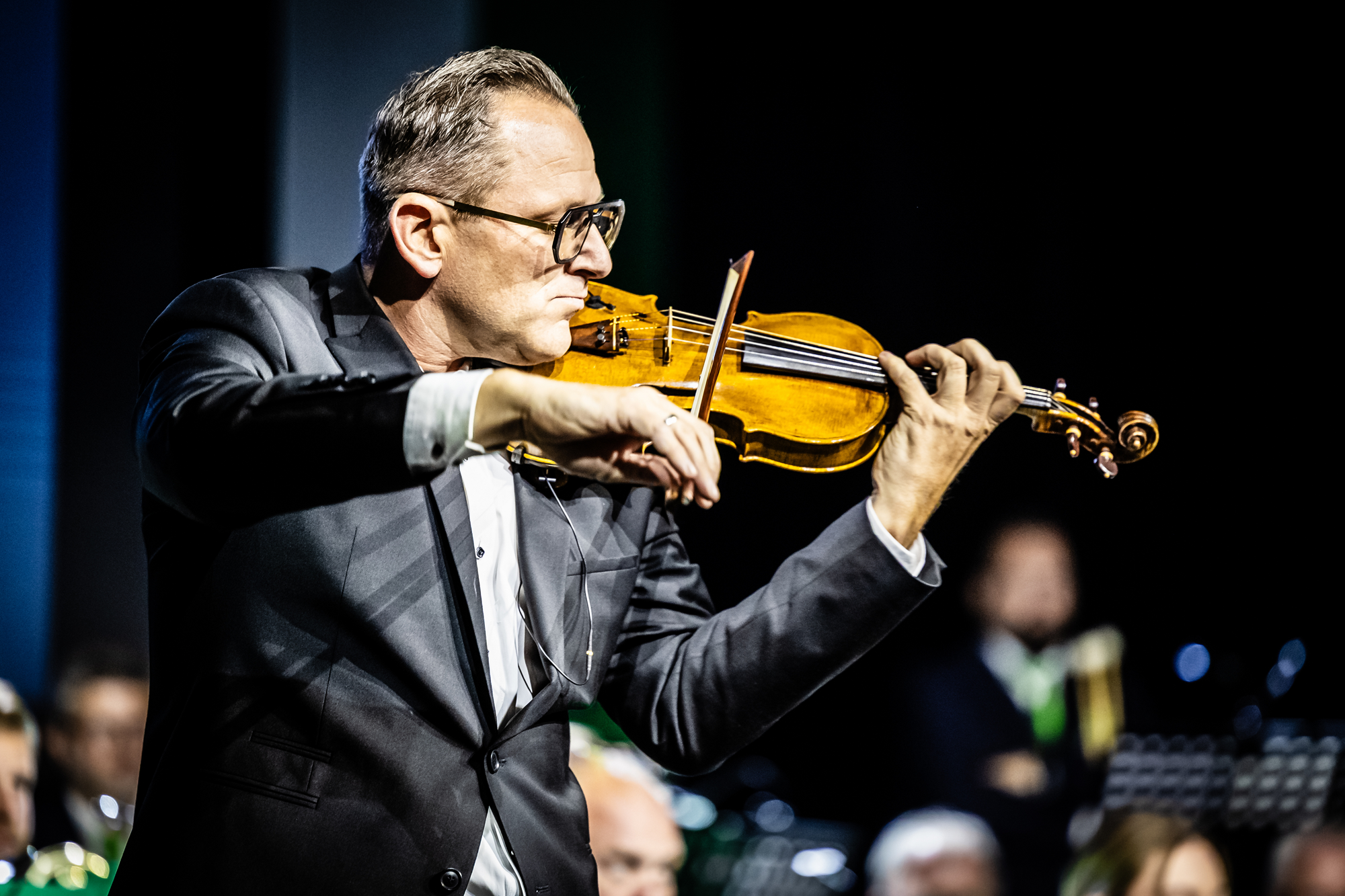 Mann spielt Geige auf der Bühne.