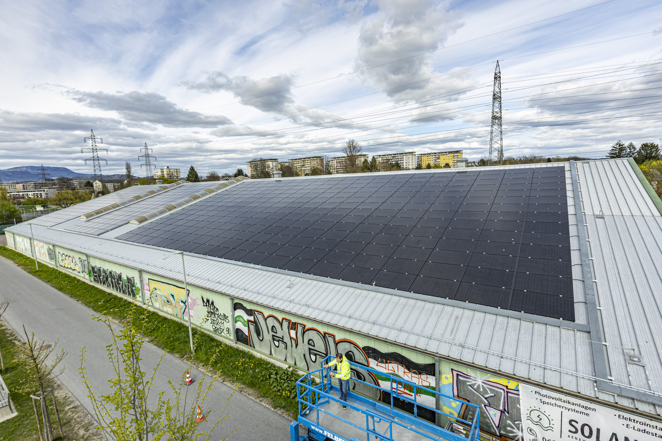 Draufsicht auf ein Gebäude mit Solaranlage in Graz, Österreich. Graffiti-Wand.