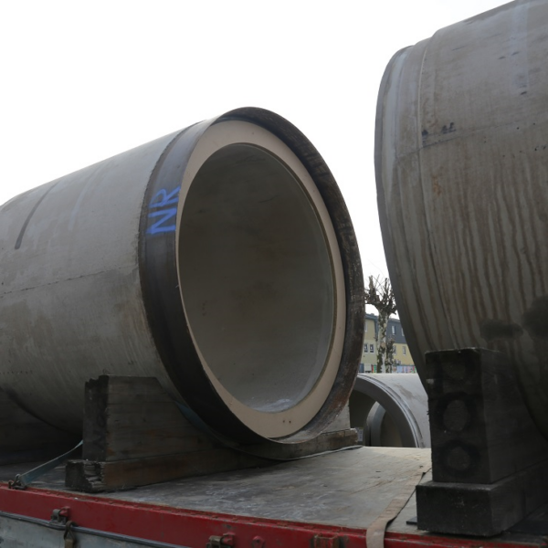 Große Betonrohre mit der Aufschrift „NR“ liegen auf einem Lastwagen.