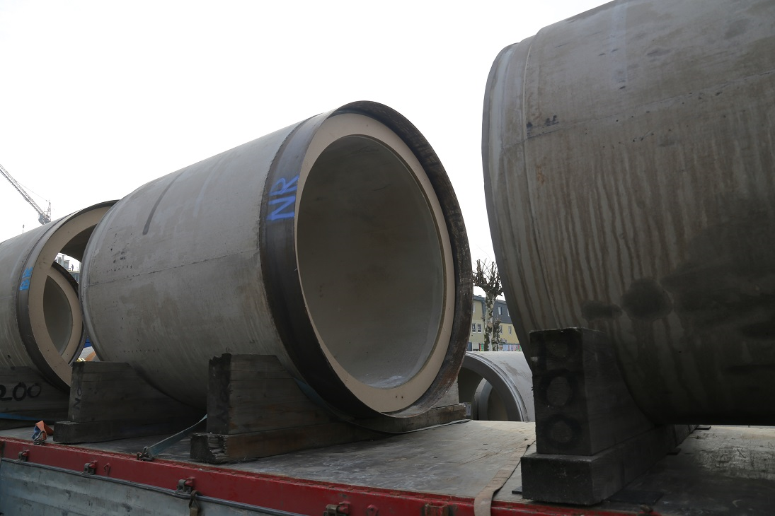 Große Betonrohre mit der Aufschrift „NR“ liegen auf einem Lastwagen.