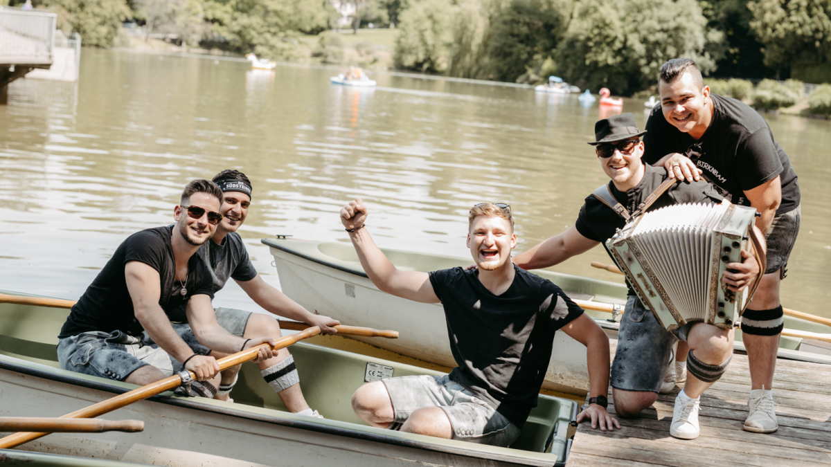 Eine Gruppe von fünf Männern mit einem Akkordeon in einem Boot in Graz.