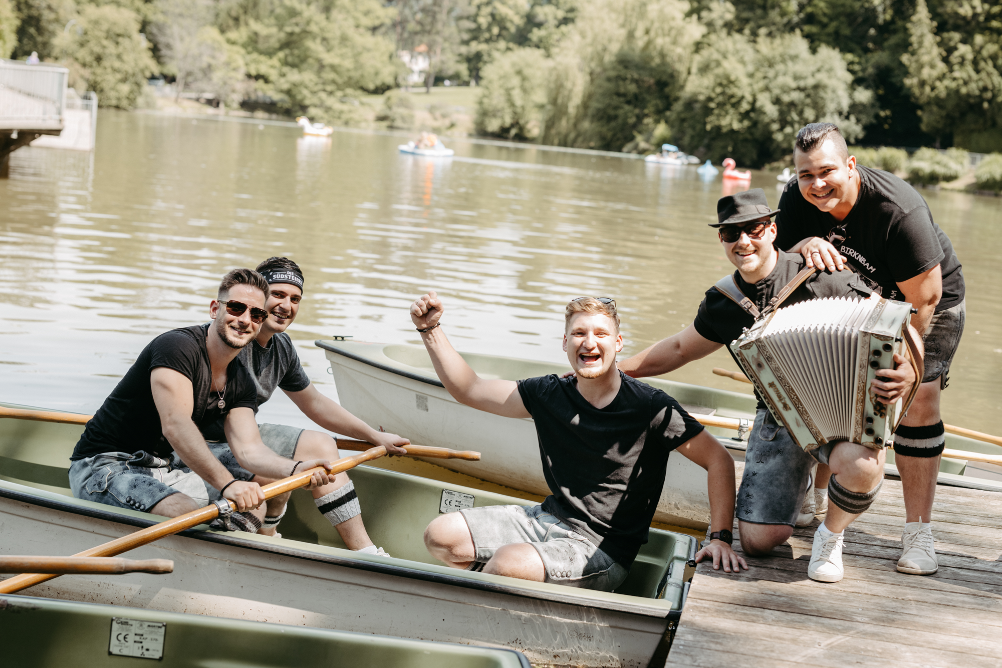 Eine Gruppe von fünf Männern mit einem Akkordeon in einem Boot in Graz.