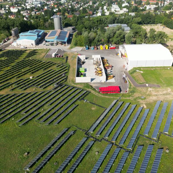 Luftaufnahme eines Solarparks in Graz mit Gebäuden und Solarmodulen.