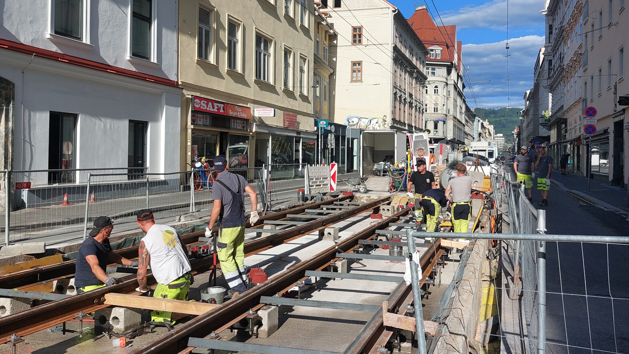 Bauarbeiter arbeiten an Straßenbahnschienen in Graz.