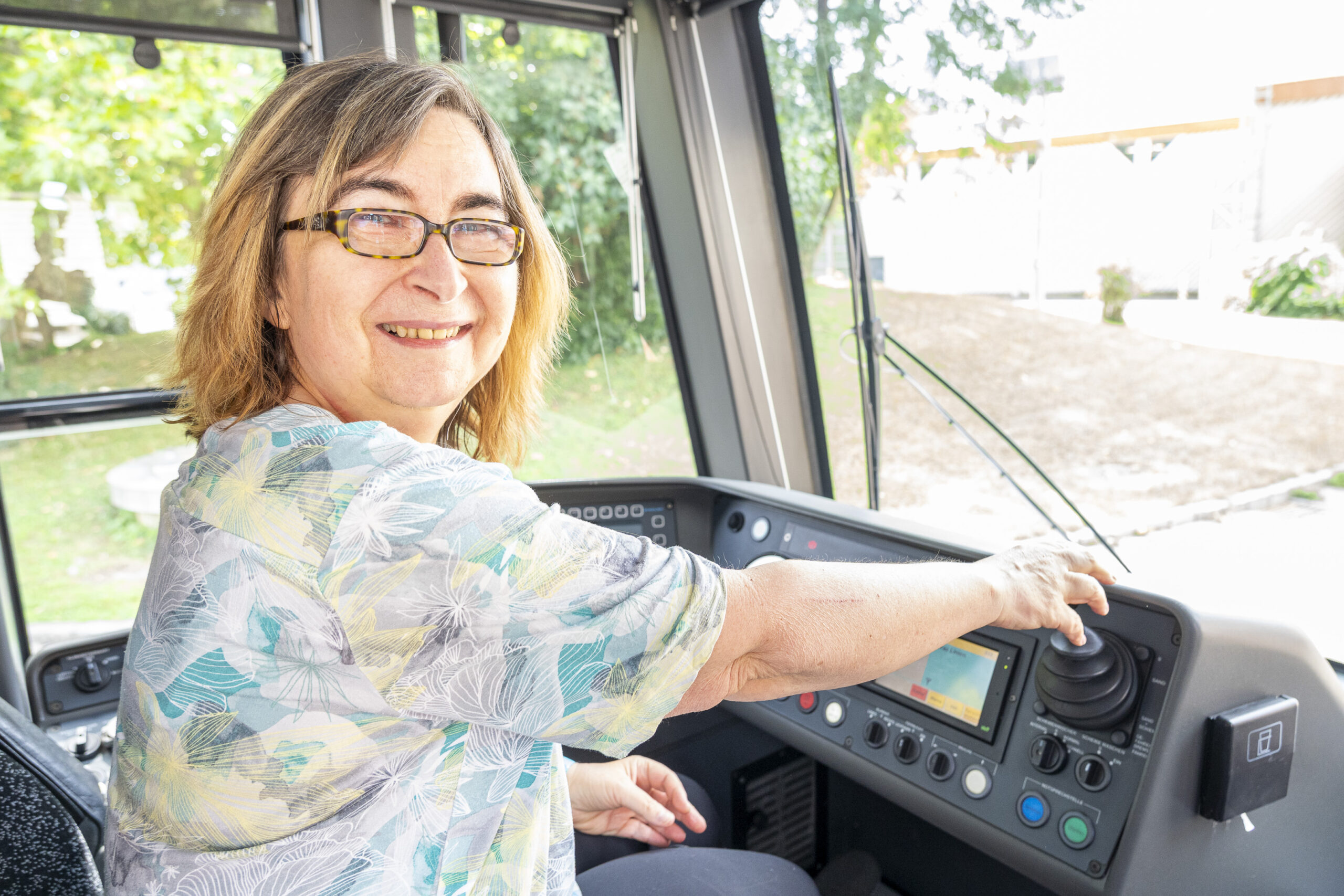 Frau mit Brille steuert Straßenbahn in Graz.