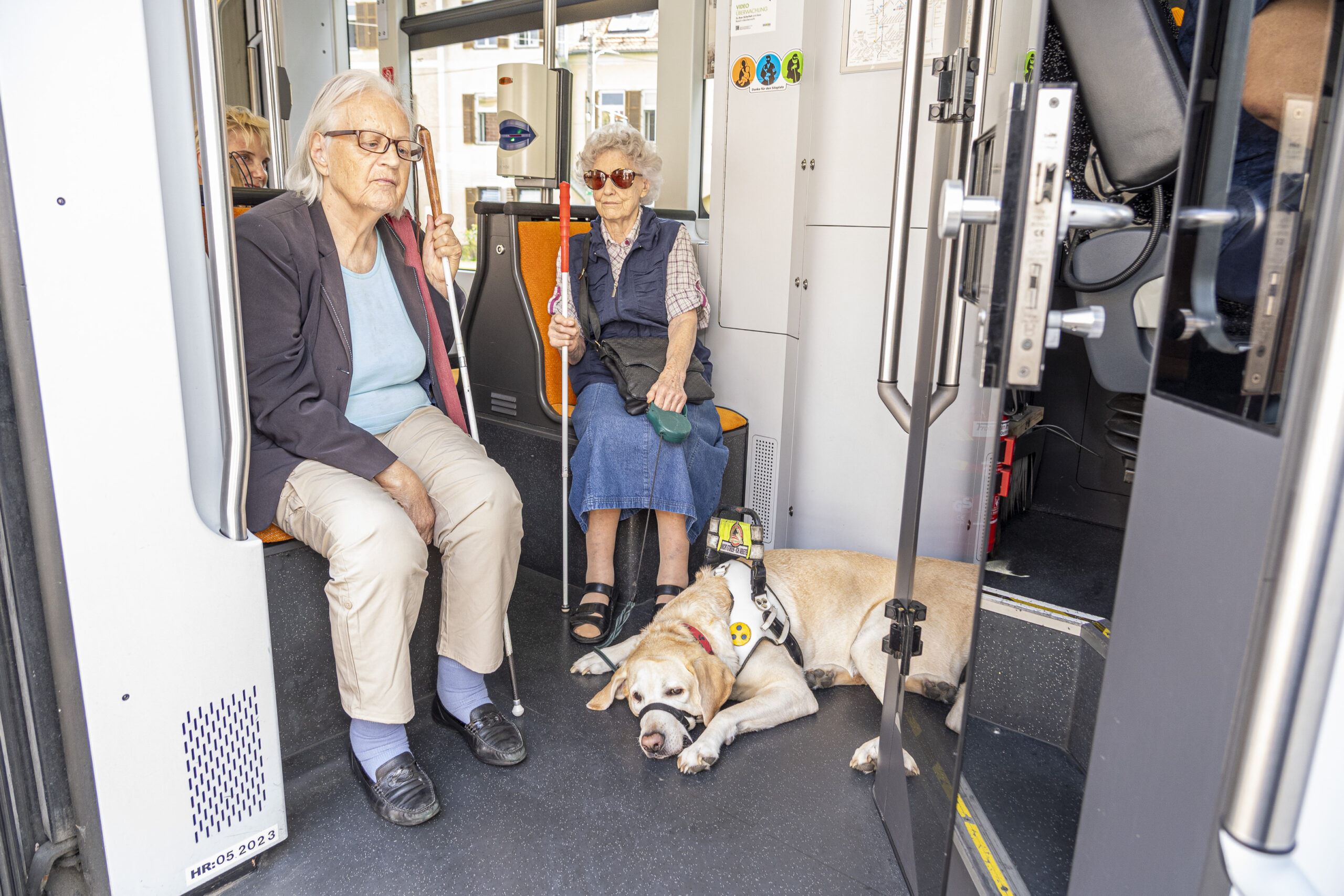 Zwei ältere Damen mit Blindenhund sitzen im Bus in Graz.