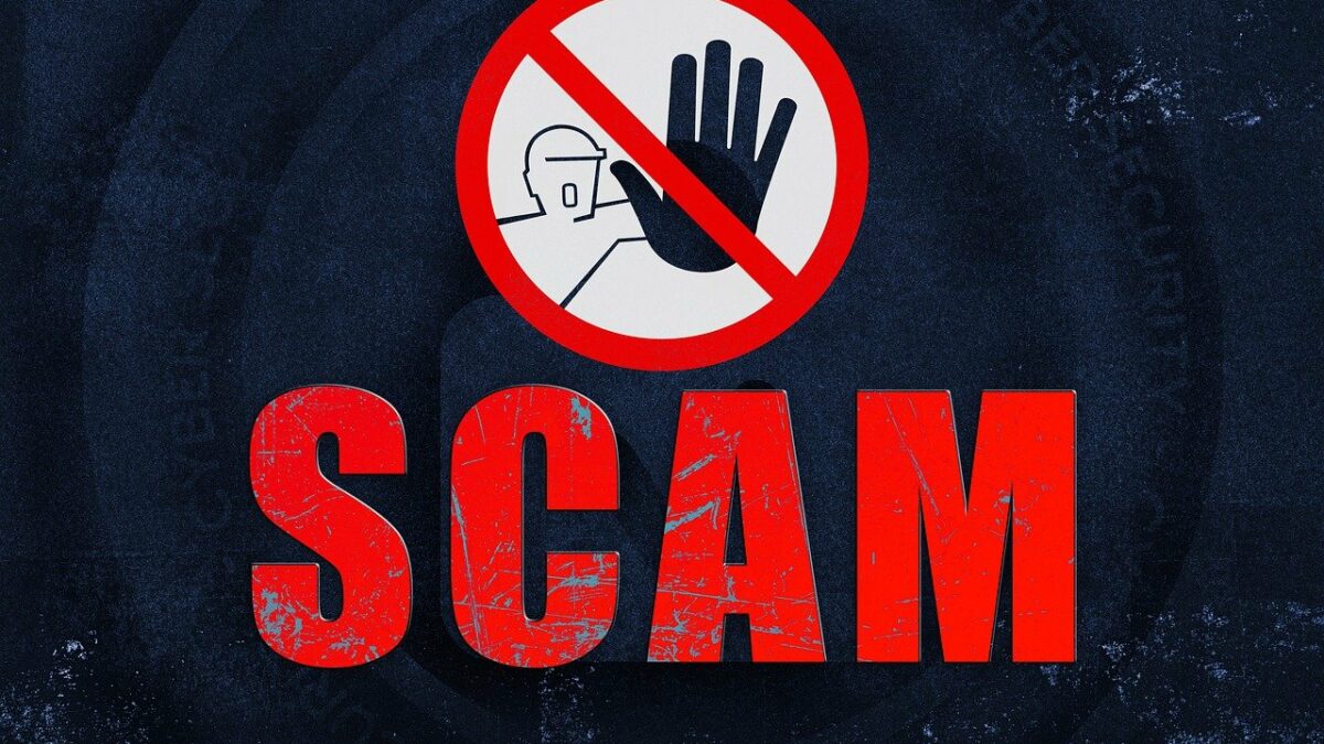 Versalien "SCAM" und ein Achtung-Schild