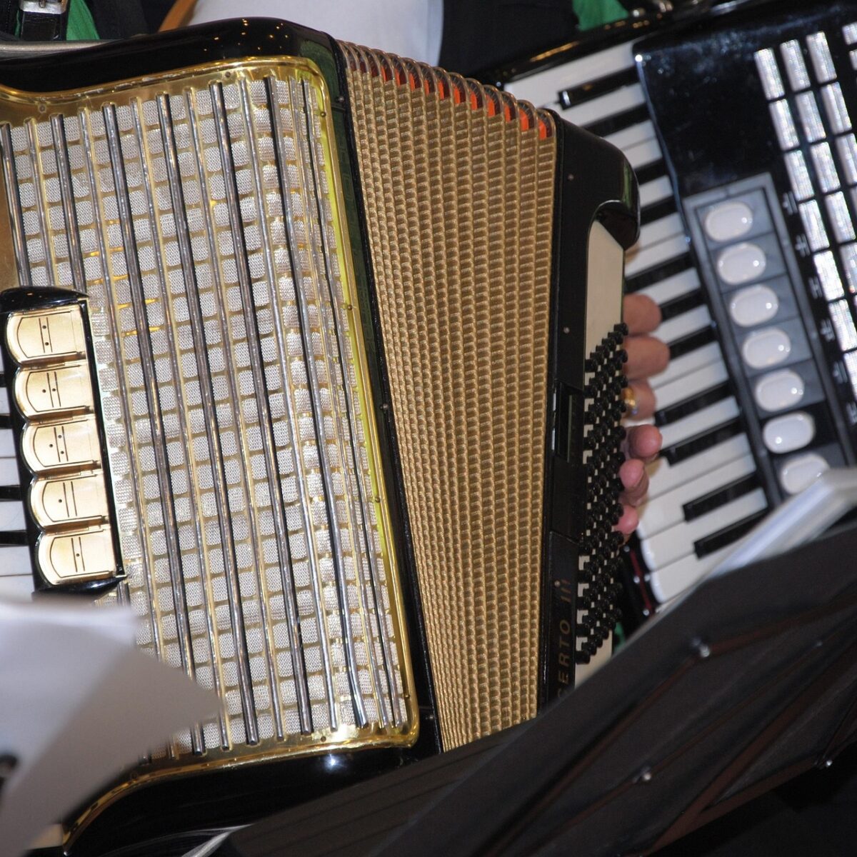 Akkordeons werden gespielt, Hände sichtbar.