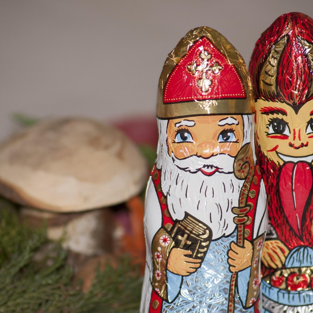 Schokoladen Nikolaus und Krampus mit Pilz im Hintergrund.
