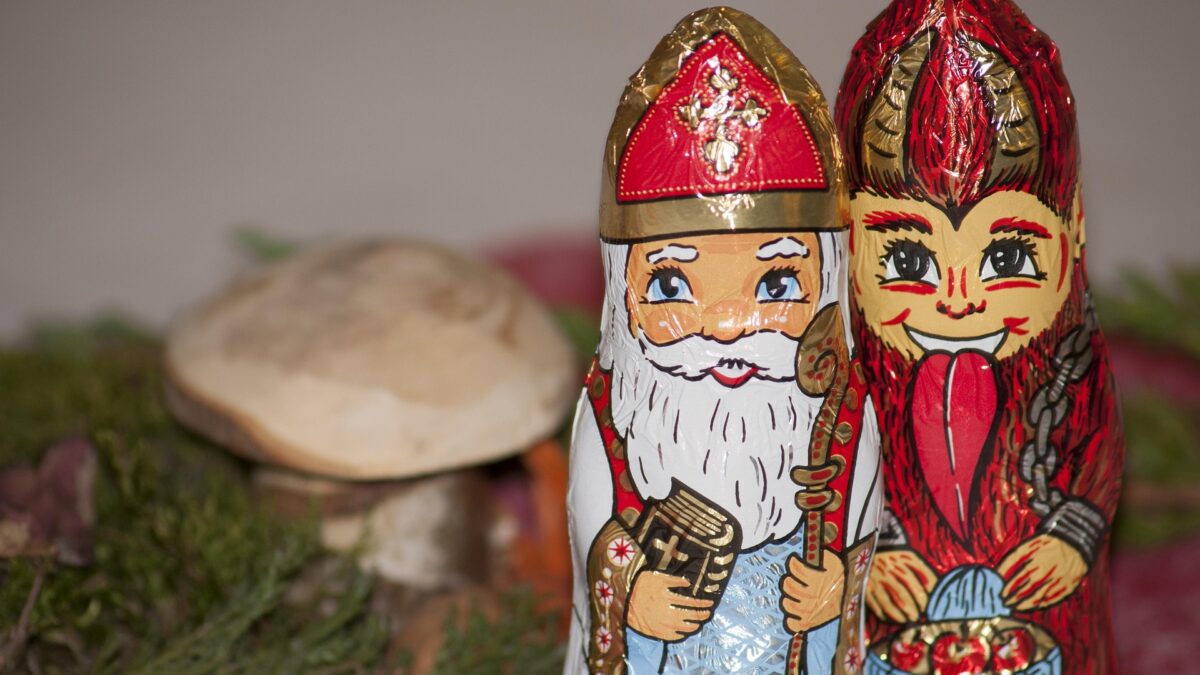Schokoladen Nikolaus und Krampus mit Pilz im Hintergrund.