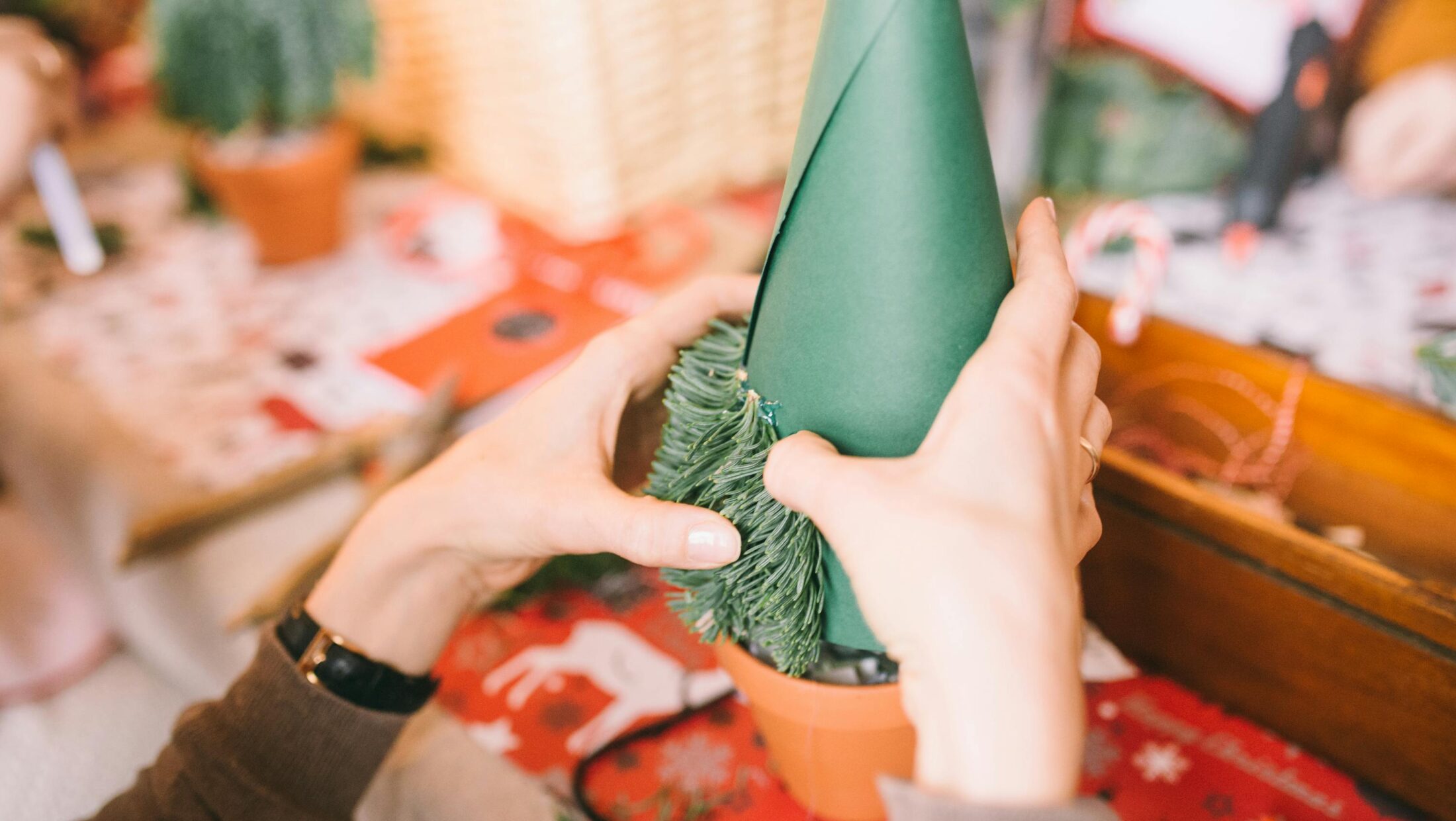 Eine Person bastelt einen kleinen Weihnachtsbaum.
