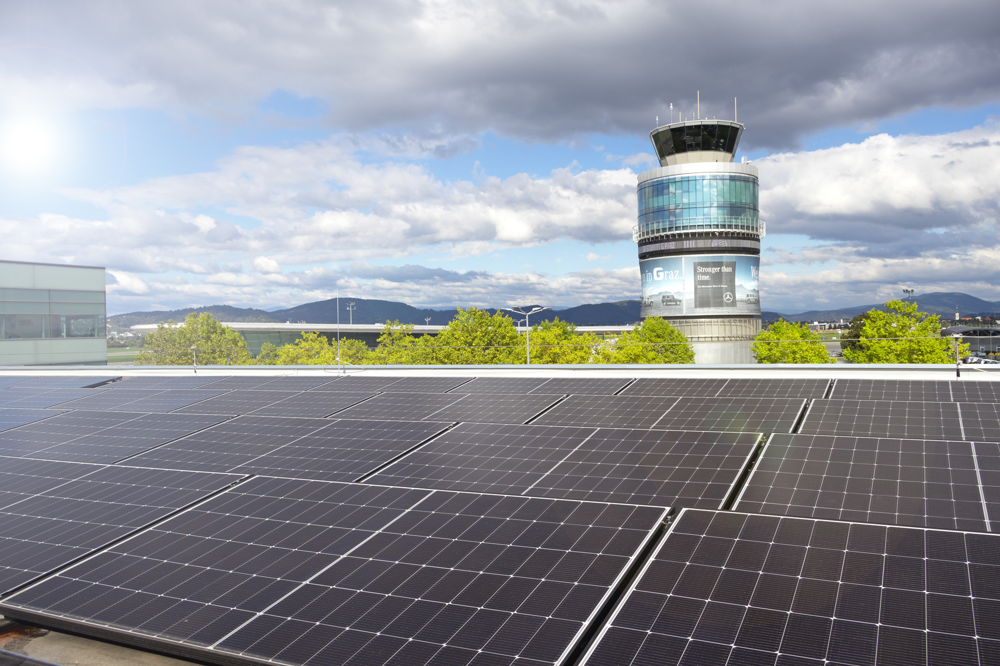 Solaranlage, Flughafen Graz im Hintergrund, Kontrollturm mit Werbung.
