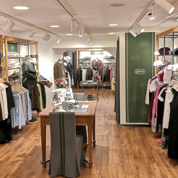 Innenraum des Gössl-Geschäfts in Graz mit Kleidung auf Kleiderbügeln und Regalen.