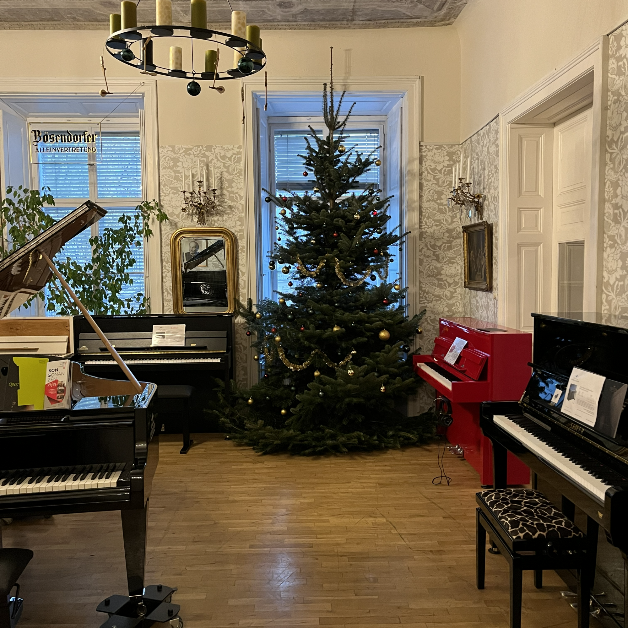 Innenraum mit Klavieren und Weihnachtsbaum in Graz.