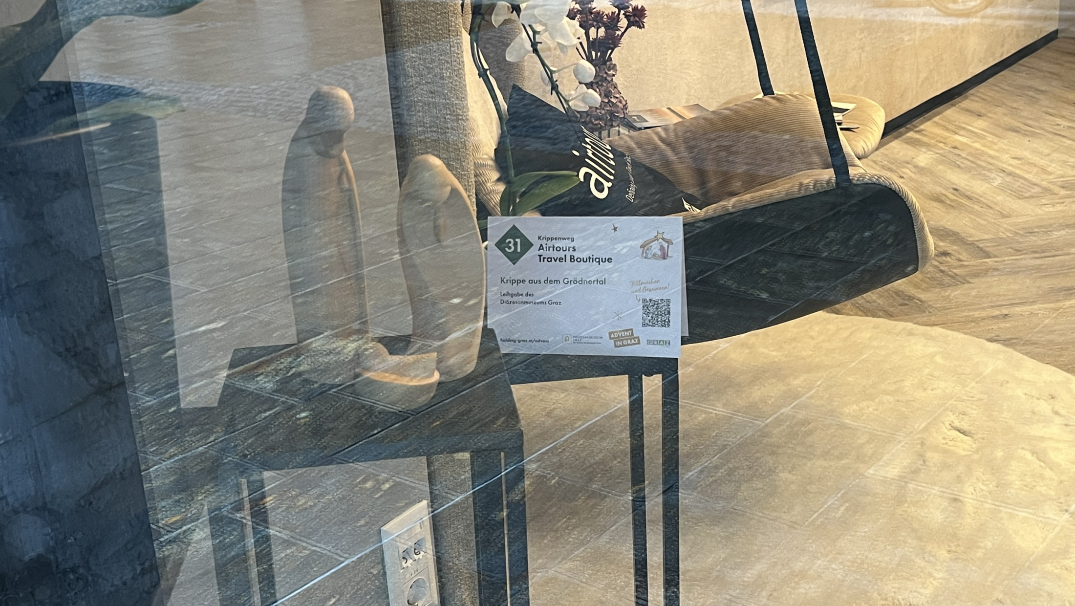 Schaufenster von Airtours Travel Boutique, Graz, mit Krippe aus dem Grödnertal.