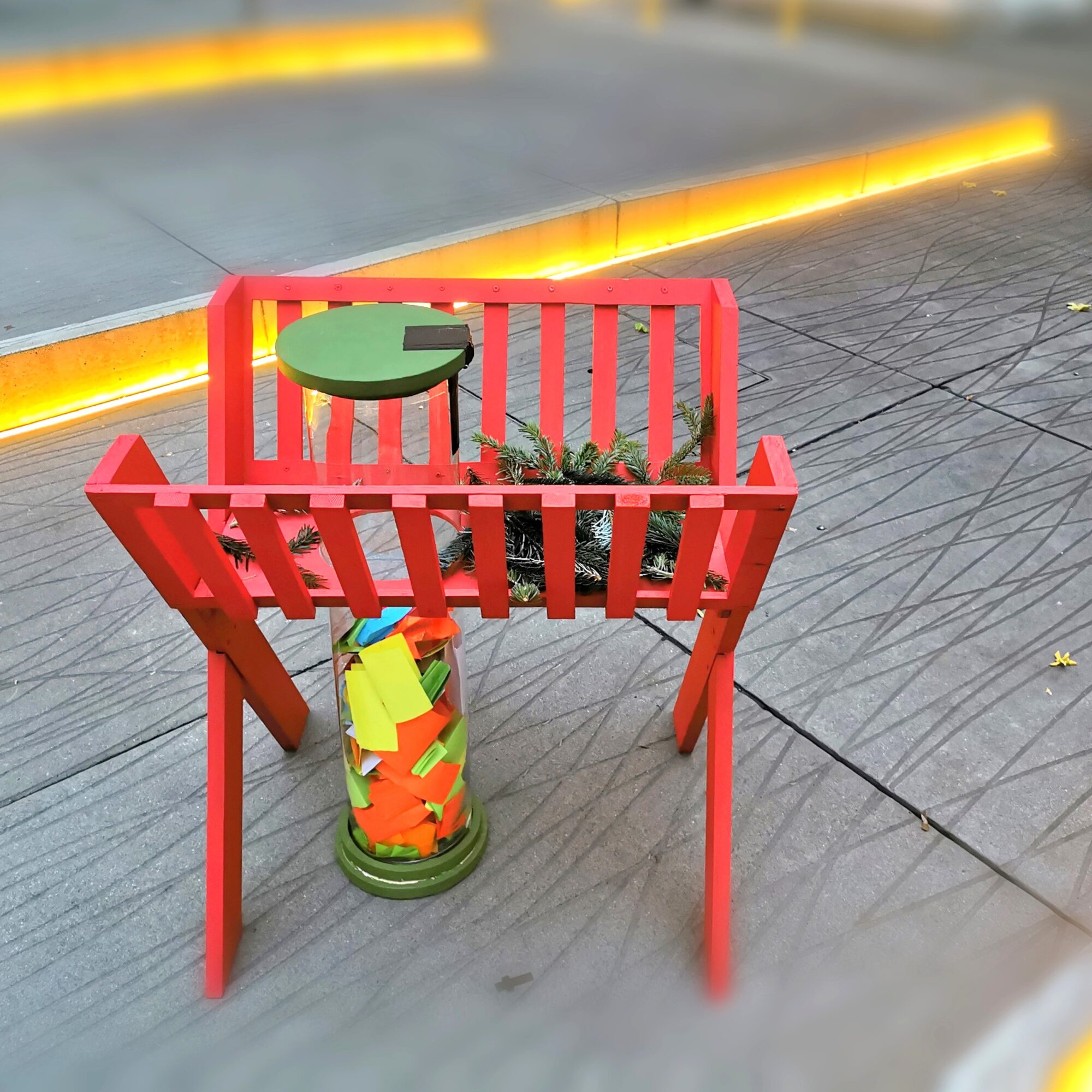 Rote Holzkonstruktion mit Zettelglas und Grünpflanze in Graz.