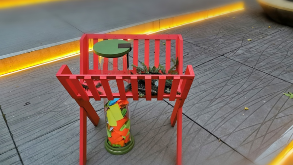 Rotes Holzgestell mit Zettelglas auf Pflaster in Graz.