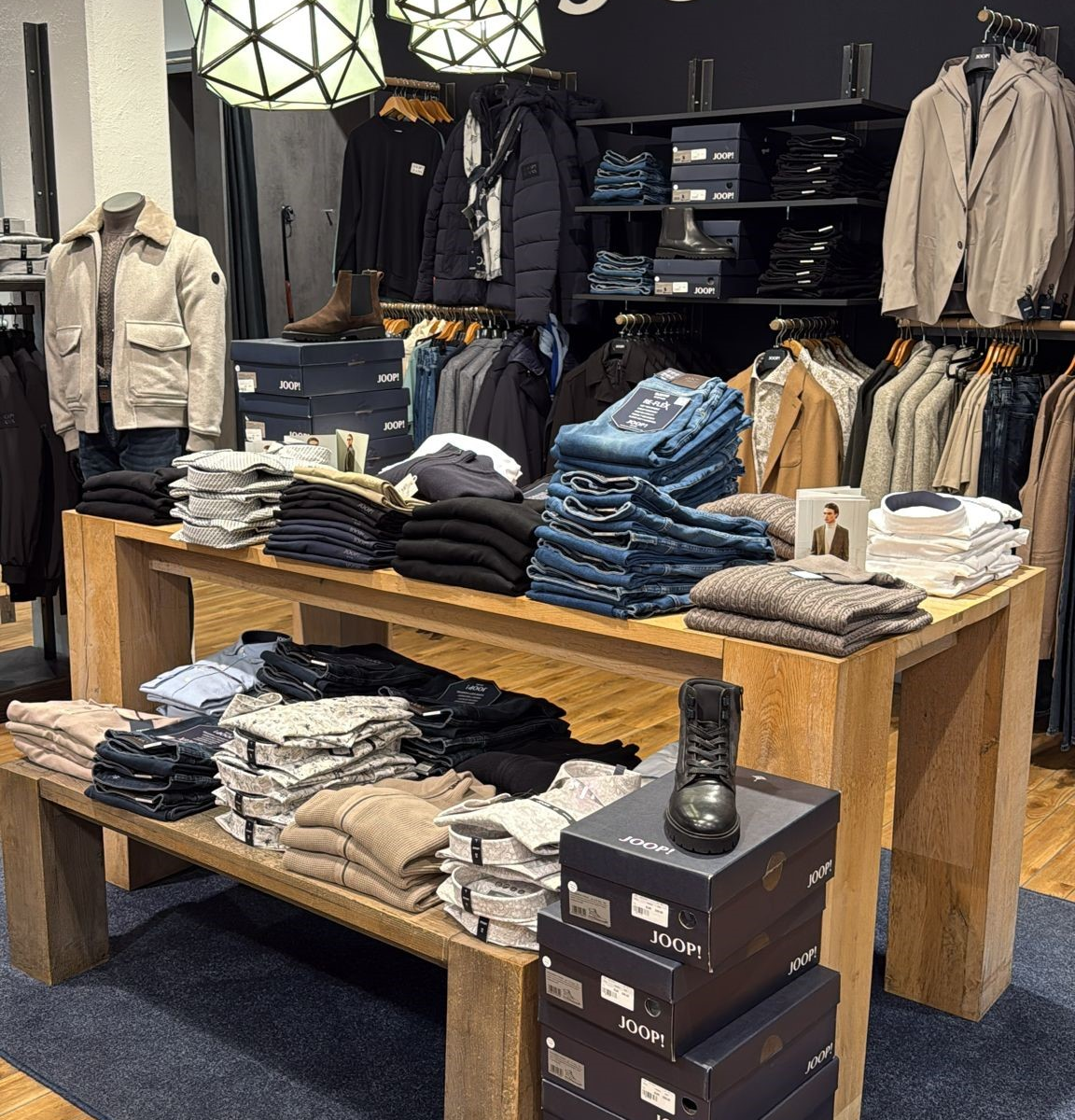 Innenraum eines JOOP!-Bekleidungsgeschäfts mit Kleidung und Schuhen.