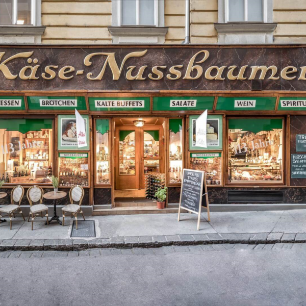 Fassade von Käse-Nussbaumer, Delikatessen, Broten, Kalte Buffets, Salate, Wein, Spirituosen.