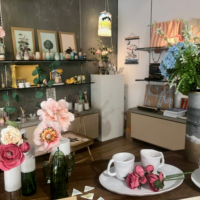 Innenaufnahme eines Ladens in Graz mit Blumen und Waren auf Regalen.