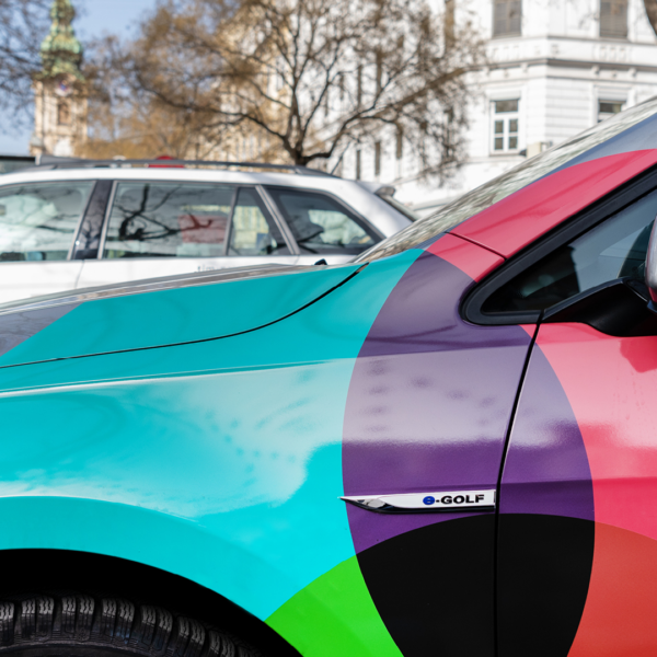 Nahaufnahme eines farbenfrohen E-Golf in Graz mit Ladestation.