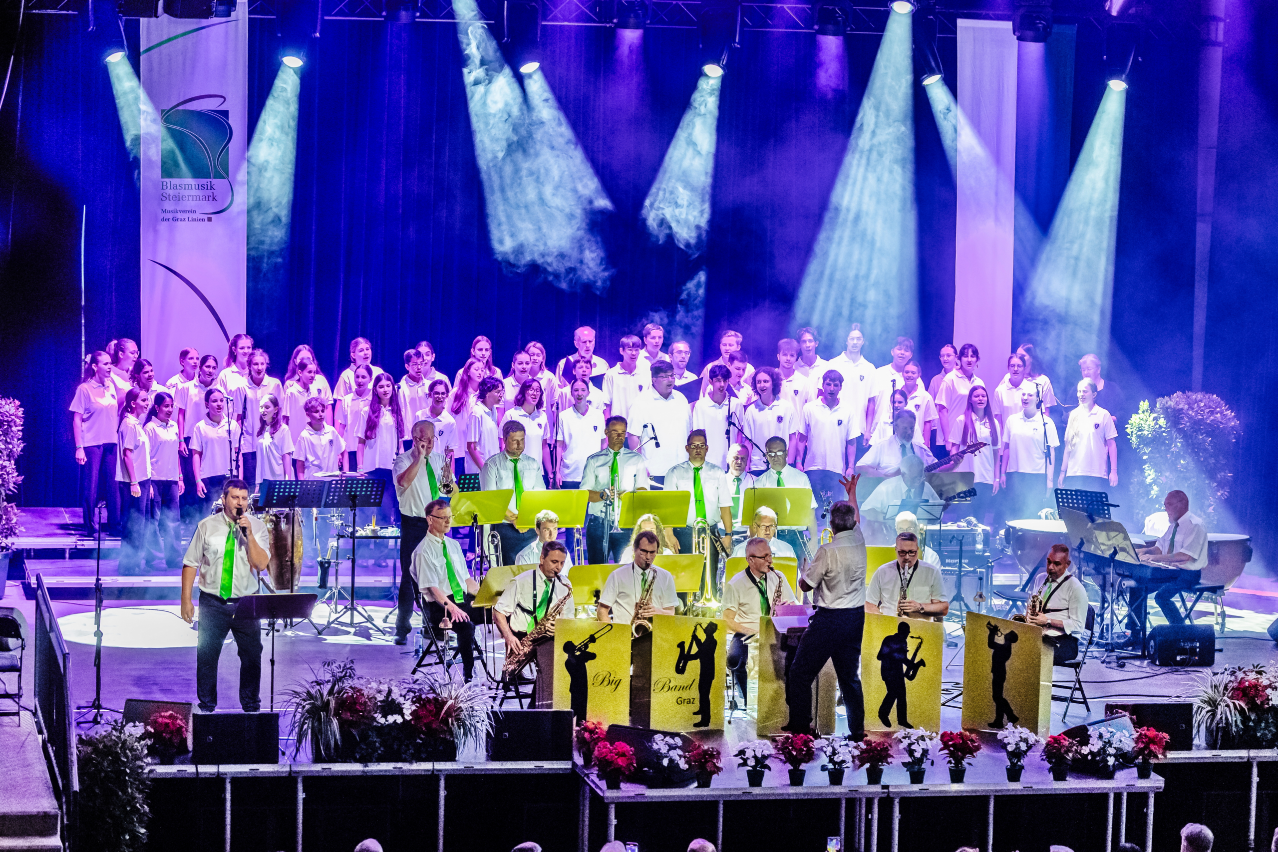 Bühne mit "Big Band Graz", Chor, Musiker und Scheinwerfern.