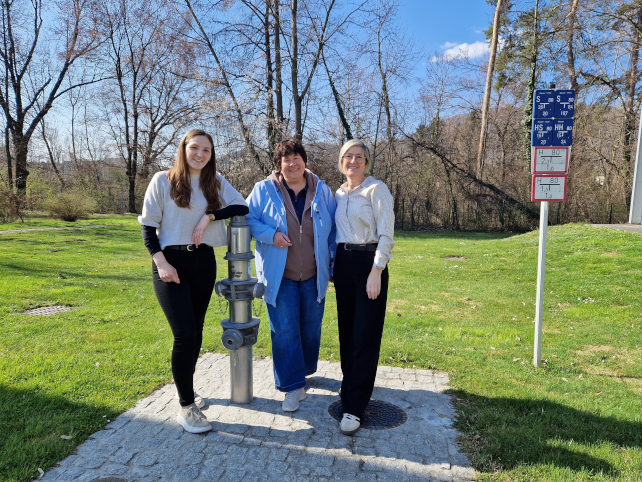 Drei Frauen posieren vor einem Hydranten in Graz an einem sonnigen Tag.