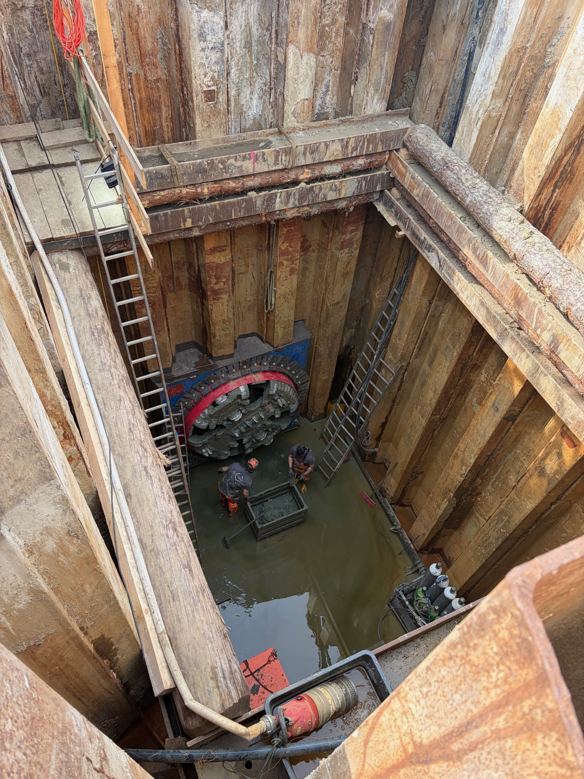Blick in eine Baugrube in Graz mit zwei Bauarbeitern und Tunnelbohrmaschine.